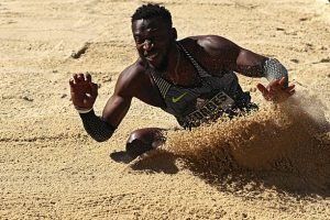 Damar Forbes mid-air during a long jump attempt at the Adidas Boost Boston Games. LandonBuford.com