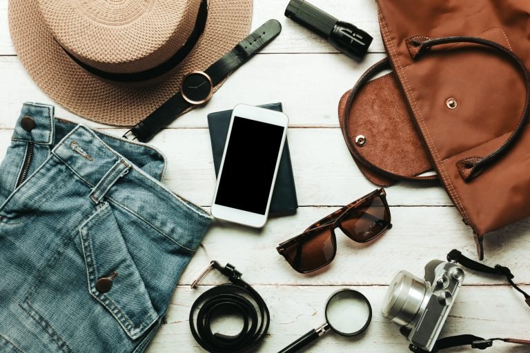 Top view accessoires to travel with women clothing concept.white