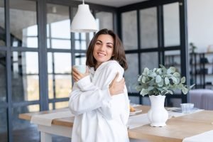 young-woman-warm-white-hoodie-home-kitchen-starts-her-day-with-cup-coffee_343596-7222