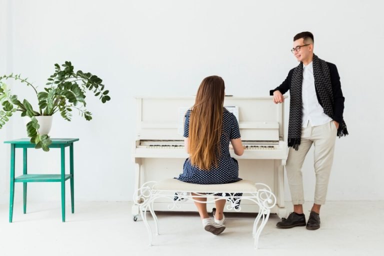 happy-young-man-with-hand-her-pocket-looking-woman-playing-piano_23-2148047540