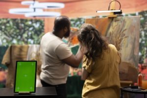 Skilled painters working on an artistic creation next to chroma key screen