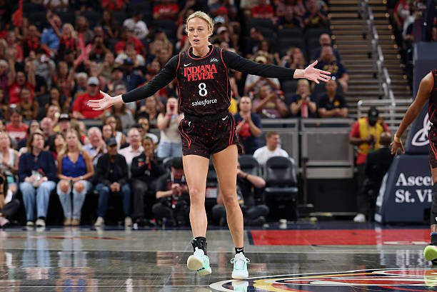 Sophie Cunningham of the Indiana Fever extends her arms during a game, wearing the team’s black and red uniform with jersey number 8. LandonBuford.com