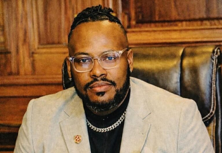 workspace with a laptop and contract papers, highlighting a $1.2M to $750K holdout in Chad Hughes’ tech project.