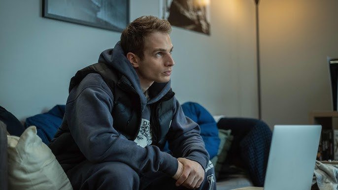 Gianni Paolo speaking at a press event with a Power Book IV: Force poster in the background.