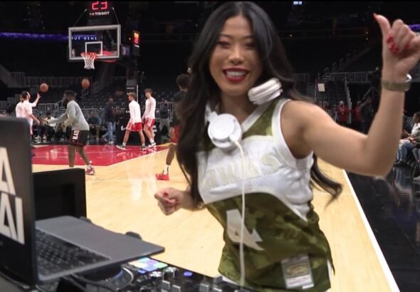 Japanese female DJ performing courtside at an Atlanta Hawks NBA game.