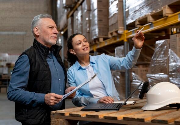 Warehouse manager reviewing digital logistics data on a tablet in a modern distribution center.